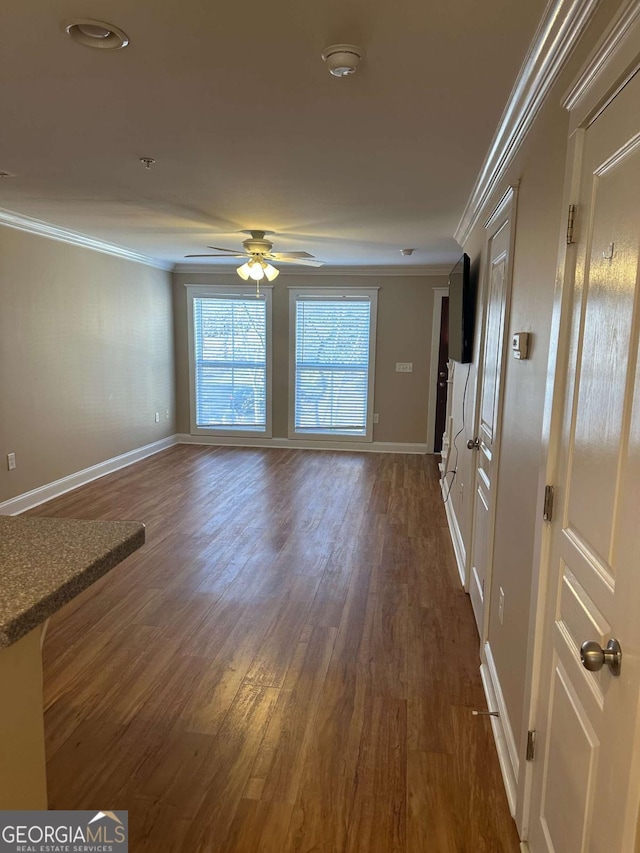 unfurnished living room with dark hardwood / wood-style flooring, ornamental molding, and ceiling fan