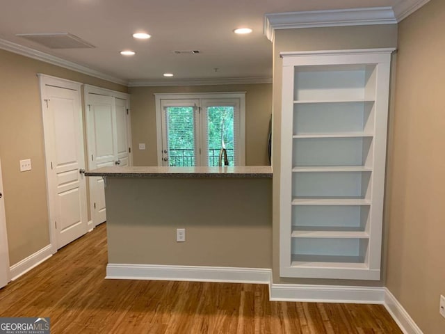 kitchen featuring hardwood / wood-style floors and crown molding