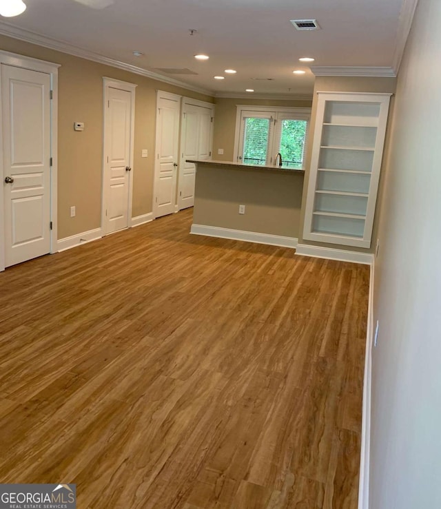 unfurnished living room featuring ornamental molding and light hardwood / wood-style flooring