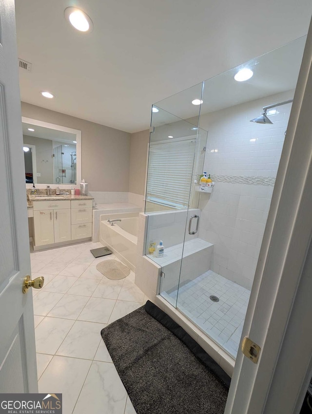 bathroom with marble finish floor, a garden tub, recessed lighting, a stall shower, and vanity