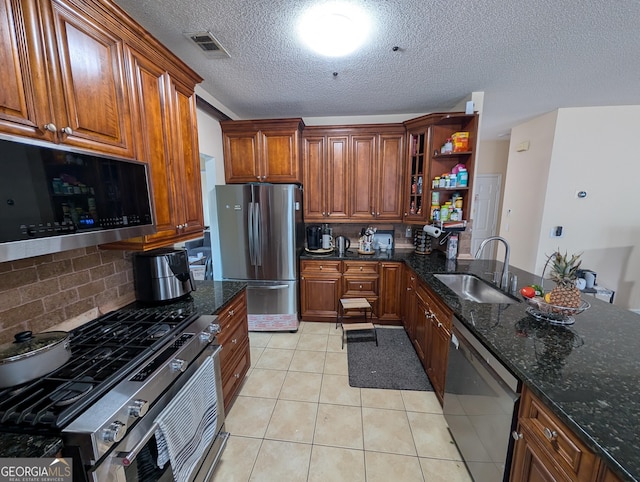 kitchen featuring light tile patterned flooring, stainless steel appliances, a sink, visible vents, and open shelves