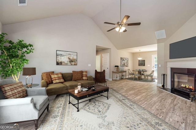 living room featuring hardwood / wood-style flooring, lofted ceiling, and ceiling fan