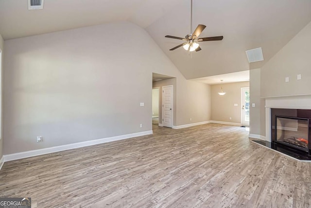 unfurnished living room featuring vaulted ceiling, ceiling fan, and light hardwood / wood-style floors