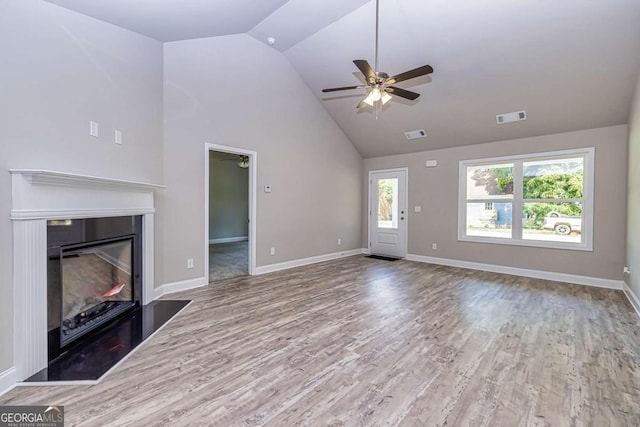 unfurnished living room featuring hardwood / wood-style flooring, high vaulted ceiling, and ceiling fan