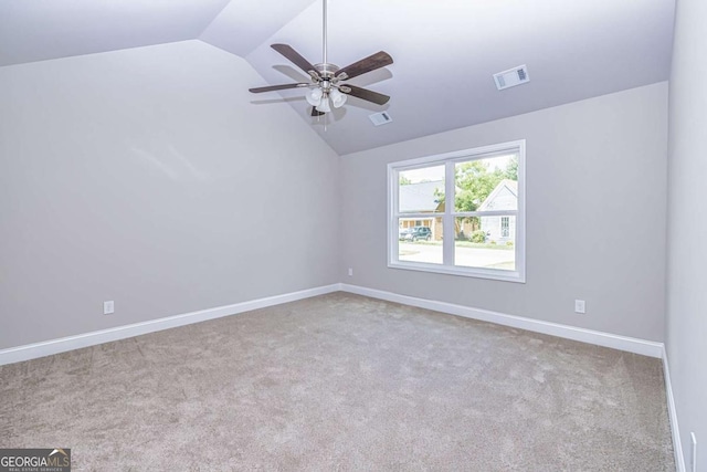 carpeted empty room with ceiling fan and lofted ceiling