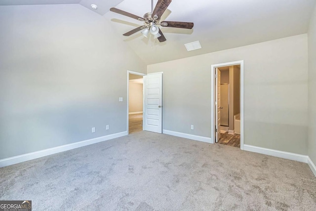 unfurnished bedroom featuring light carpet, vaulted ceiling, ceiling fan, and ensuite bathroom