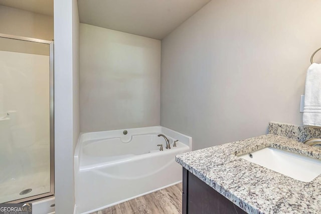 bathroom featuring hardwood / wood-style flooring, vanity, and separate shower and tub