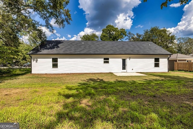 back of property with a patio area and a lawn