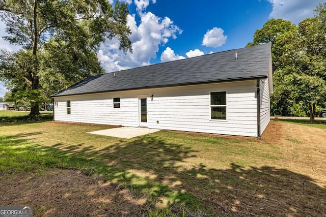 back of house with a patio and a lawn