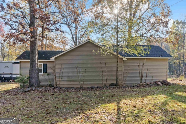 view of side of home with a yard