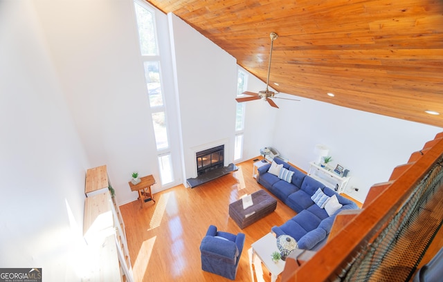 living room featuring ceiling fan, high vaulted ceiling, wood ceiling, and light hardwood / wood-style floors