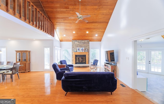 living room with french doors, high vaulted ceiling, light hardwood / wood-style flooring, wooden ceiling, and a fireplace