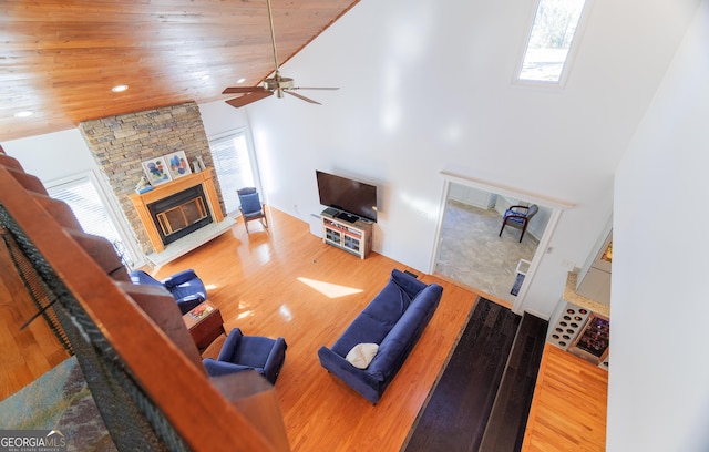 living room featuring hardwood / wood-style floors, wood ceiling, a fireplace, and high vaulted ceiling