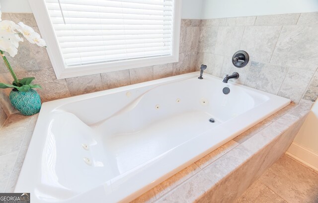 bathroom featuring a relaxing tiled tub and tile patterned flooring