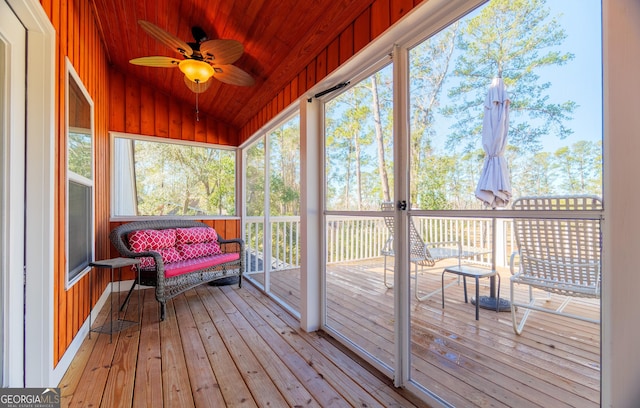 sunroom with lofted ceiling, wooden ceiling, and ceiling fan