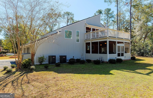 back of house with central AC, a yard, and a sunroom