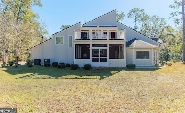 rear view of property featuring central AC, a balcony, and a yard