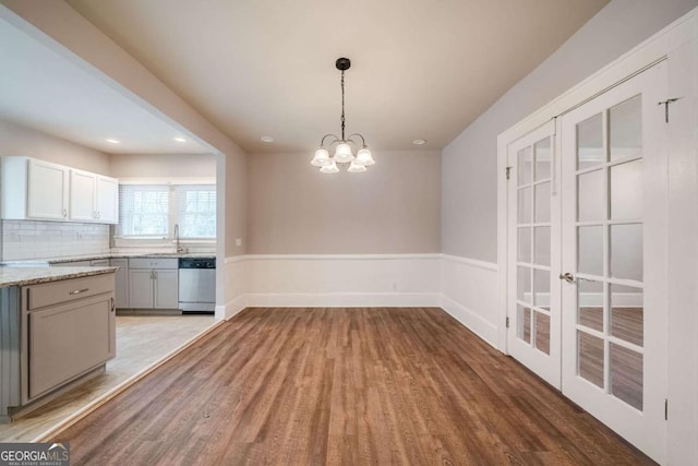 3693 Aldea Dr, Decatur, GA 30032 - unfurnished dining area featuring sink, light hardwood / wood-style flooring, and a notable chandelier