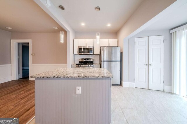 3693 Aldea Dr, Decatur, GA 30032 - kitchen featuring white cabinetry, stainless steel appliances, light stone counters, and pendant lighting
