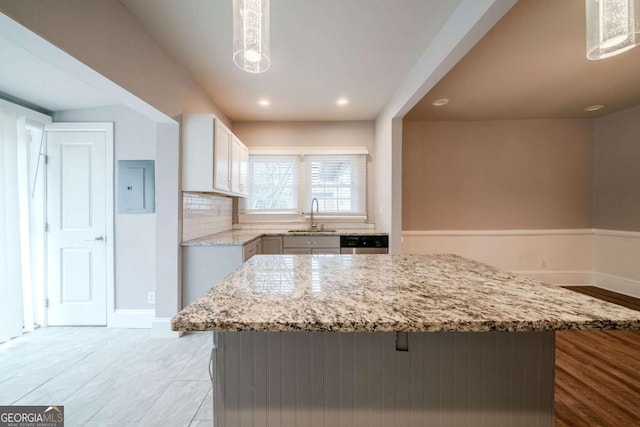 3693 Aldea Dr, Decatur, GA 30032 - kitchen with white cabinetry, hanging light fixtures, light stone counters, and sink