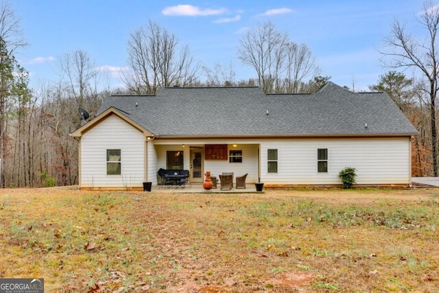 rear view of property with a patio and a lawn