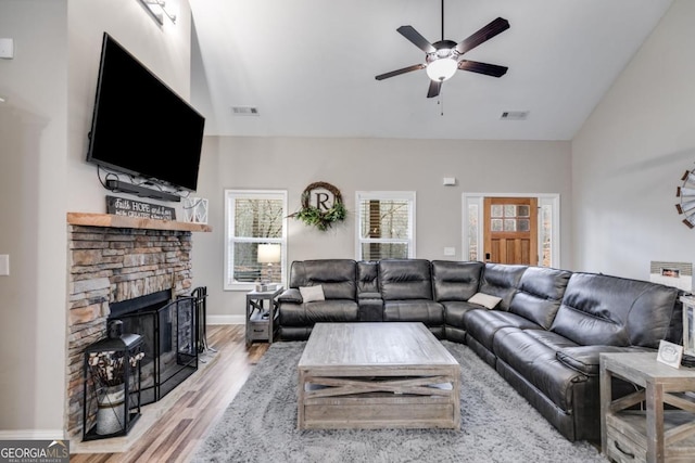 living room featuring ceiling fan, a fireplace, and light hardwood / wood-style flooring