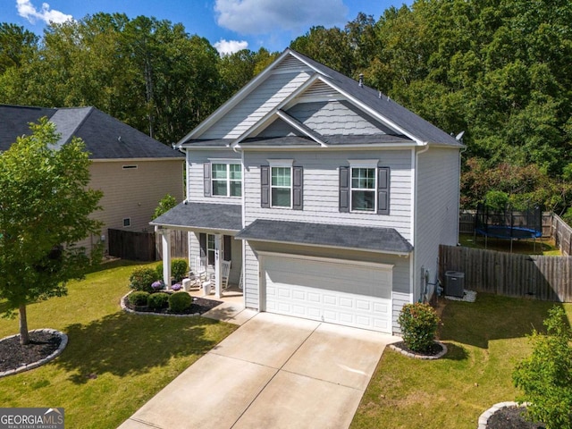 view of front of property with a trampoline, central AC unit, a garage, and a front lawn