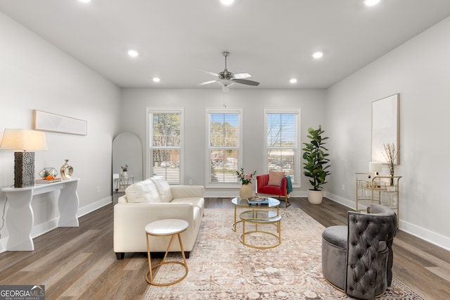 living room with dark wood-type flooring and ceiling fan