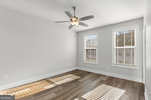 unfurnished room featuring dark wood-type flooring and ceiling fan