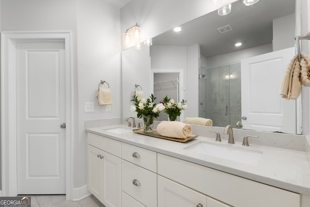 bathroom featuring tile patterned floors, vanity, and a shower with door