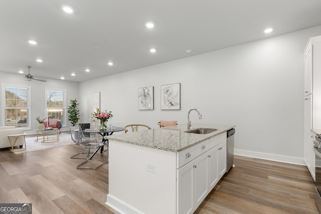 kitchen with white cabinetry, sink, appliances with stainless steel finishes, and a center island with sink