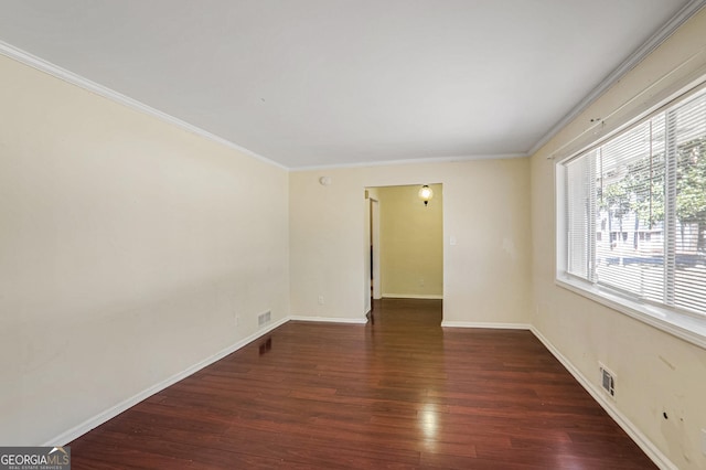 spare room featuring ornamental molding and dark hardwood / wood-style floors