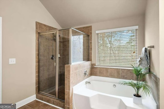 bathroom with tile patterned flooring, vaulted ceiling, and plus walk in shower