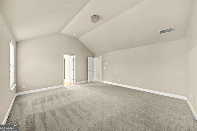 additional living space with lofted ceiling and carpet