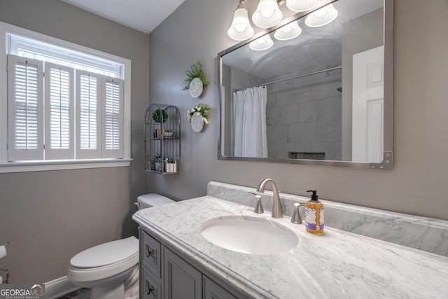 bathroom featuring a shower with curtain, vanity, and toilet