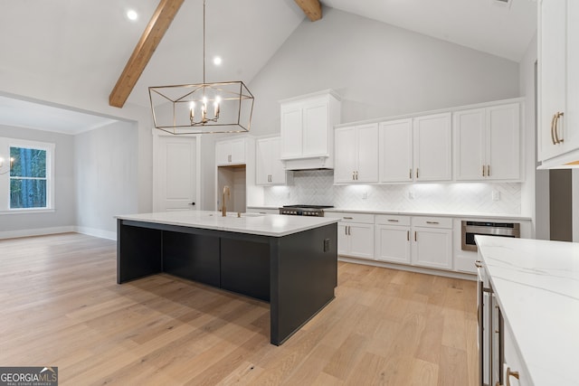 kitchen with white cabinets, high vaulted ceiling, an island with sink, and beamed ceiling