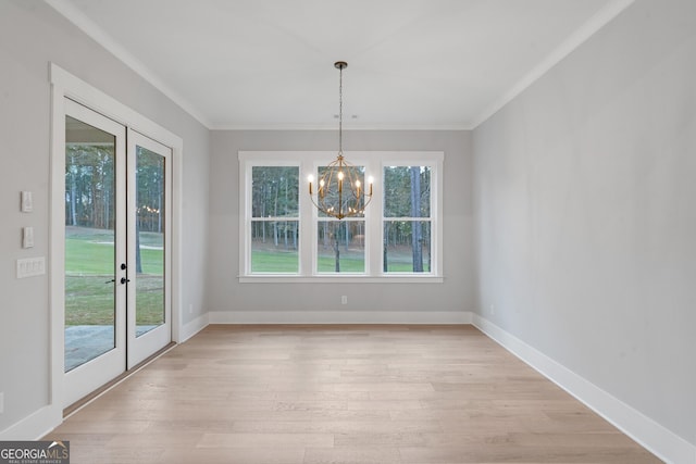 unfurnished dining area with an inviting chandelier, plenty of natural light, and light wood-type flooring