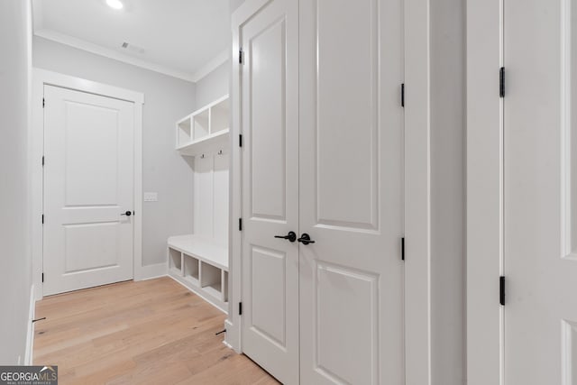 mudroom featuring crown molding and light hardwood / wood-style flooring