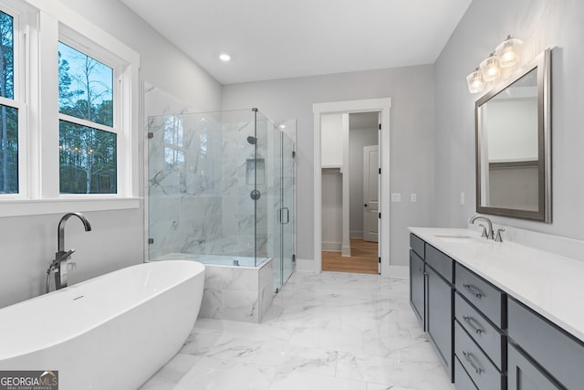 bathroom featuring a healthy amount of sunlight, independent shower and bath, and vanity