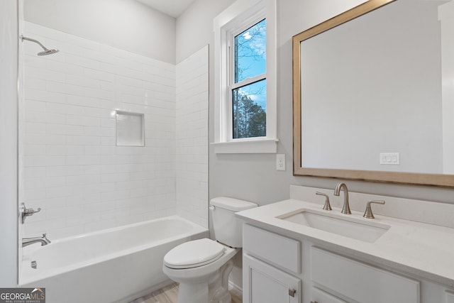 full bathroom with tiled shower / bath, vanity, and toilet