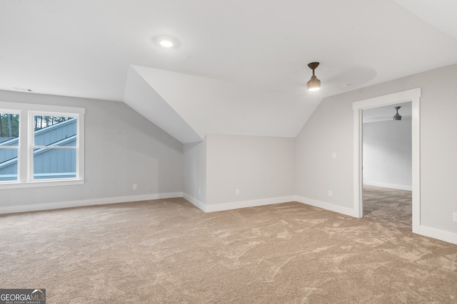 additional living space with lofted ceiling and light carpet