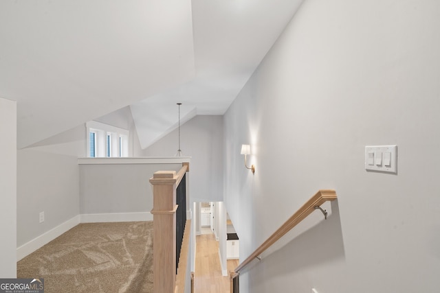 stairs with lofted ceiling and carpet flooring