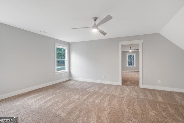 carpeted spare room with vaulted ceiling and ceiling fan