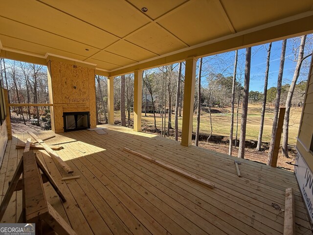 wooden deck featuring a large fireplace