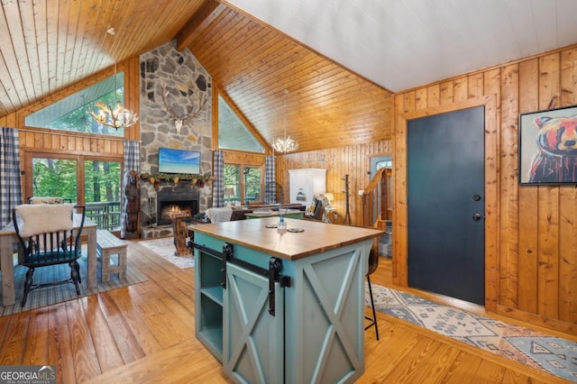 kitchen featuring a notable chandelier, a center island, light wood-type flooring, and vaulted ceiling with beams