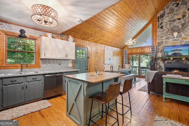 kitchen with gray cabinets, dishwasher, a center island, a notable chandelier, and white cabinets