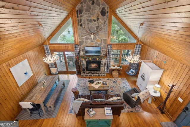 unfurnished living room with an inviting chandelier, high vaulted ceiling, and hardwood / wood-style flooring