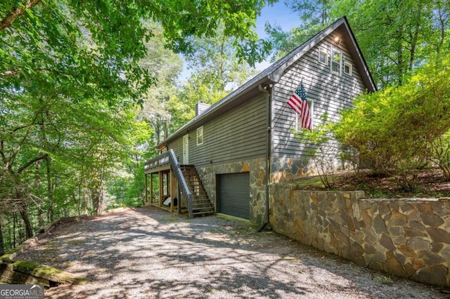 view of side of home with a wooden deck and a garage