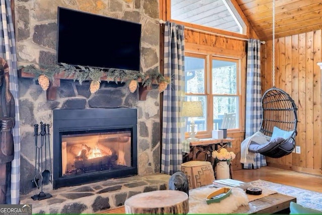 interior space with lofted ceiling, wood ceiling, hardwood / wood-style flooring, wooden walls, and a fireplace