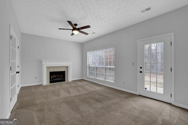 unfurnished living room with a wealth of natural light, light colored carpet, and a fireplace